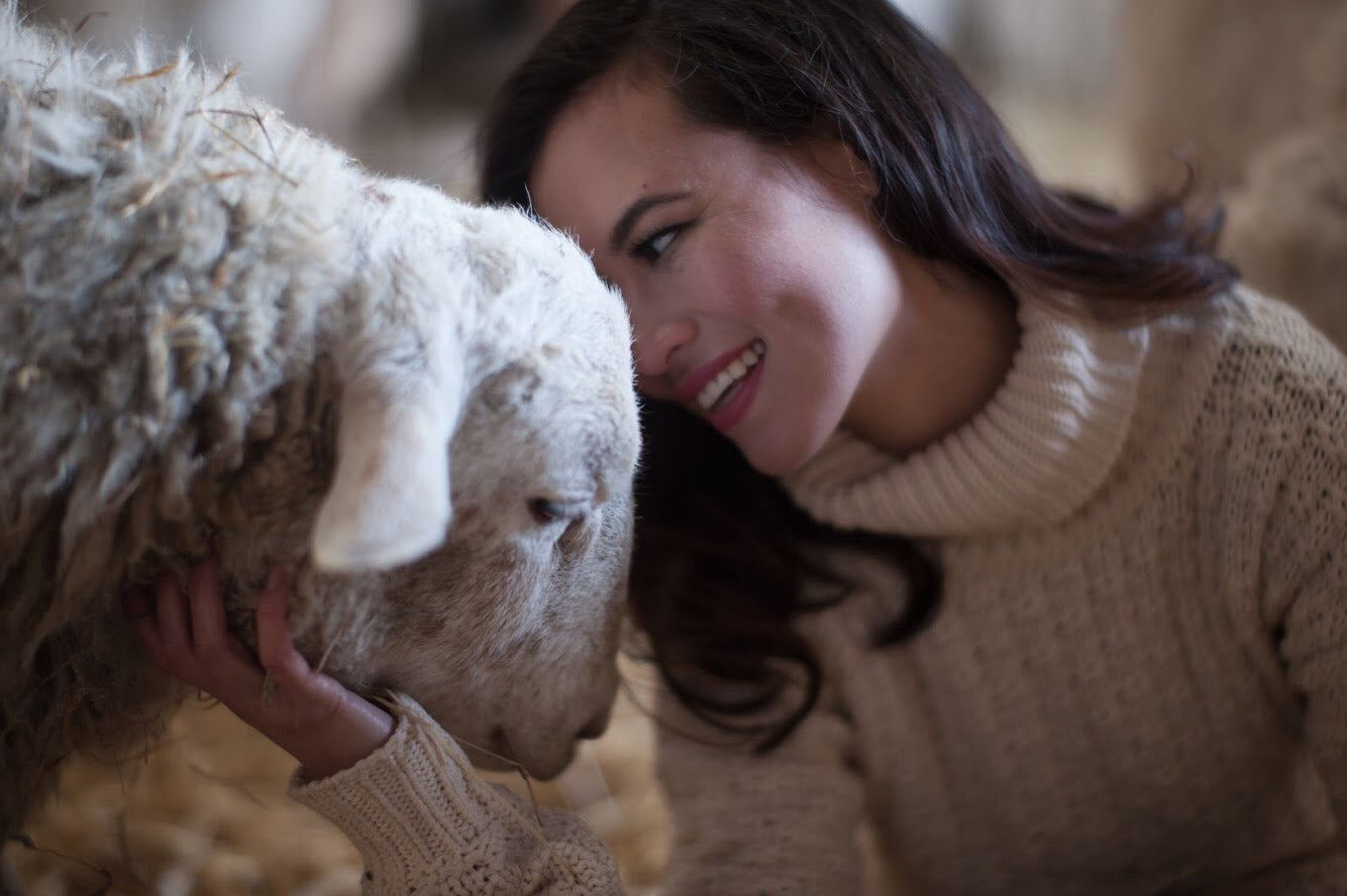 Leanne Mai-ly Hilgart, vegan fashion designer, at Farm Sanctuary with Rescued Sheep Joel, as photographed by Anthony TwoMoons.